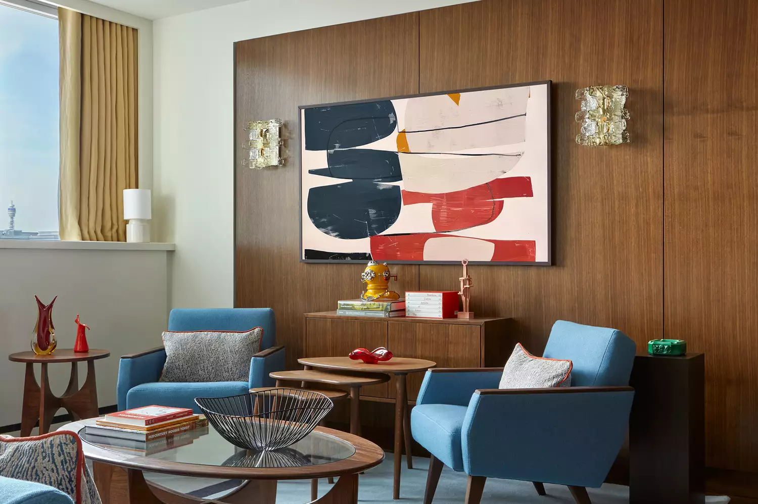 A living room in the Mid Century Cabin Suite featuring designer furniture and riverside views.