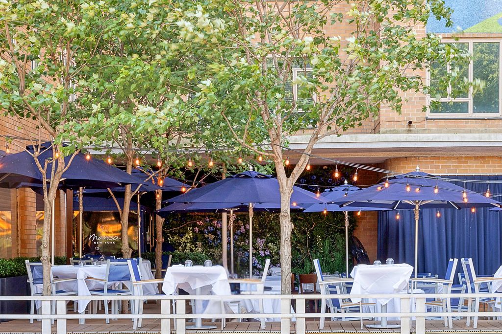 Exterior dining area of Marea with deep blue furnishings and high-end restaurant architecture.