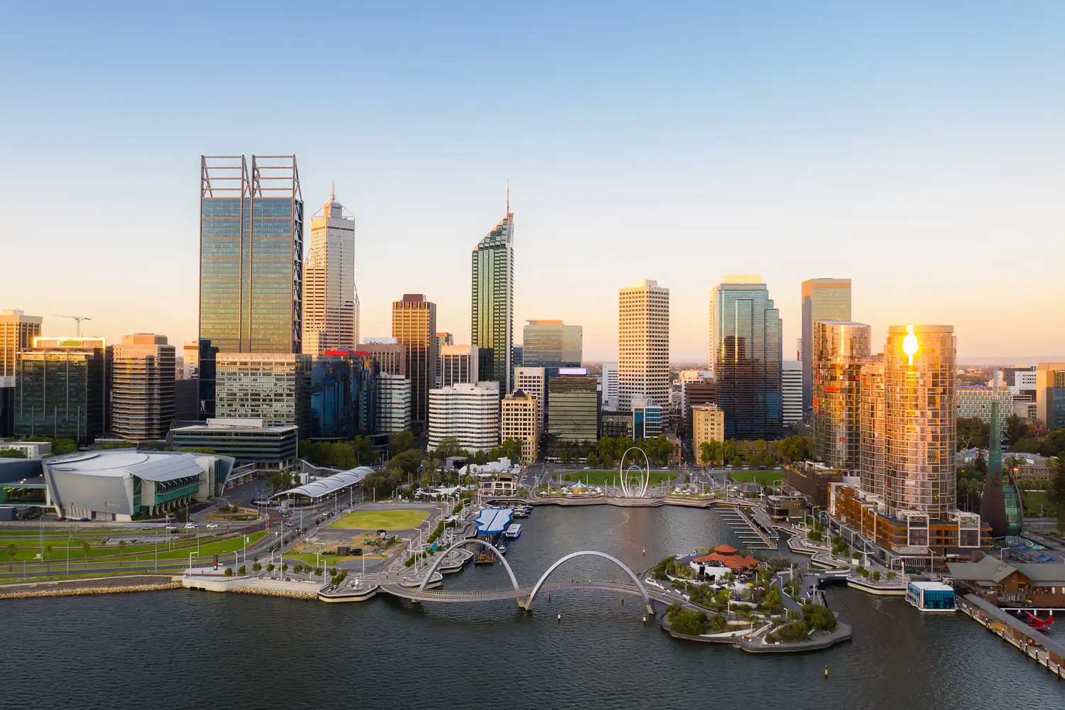 The modern skyline of Perth and the Elizabeth Quay waterfront at sunset.