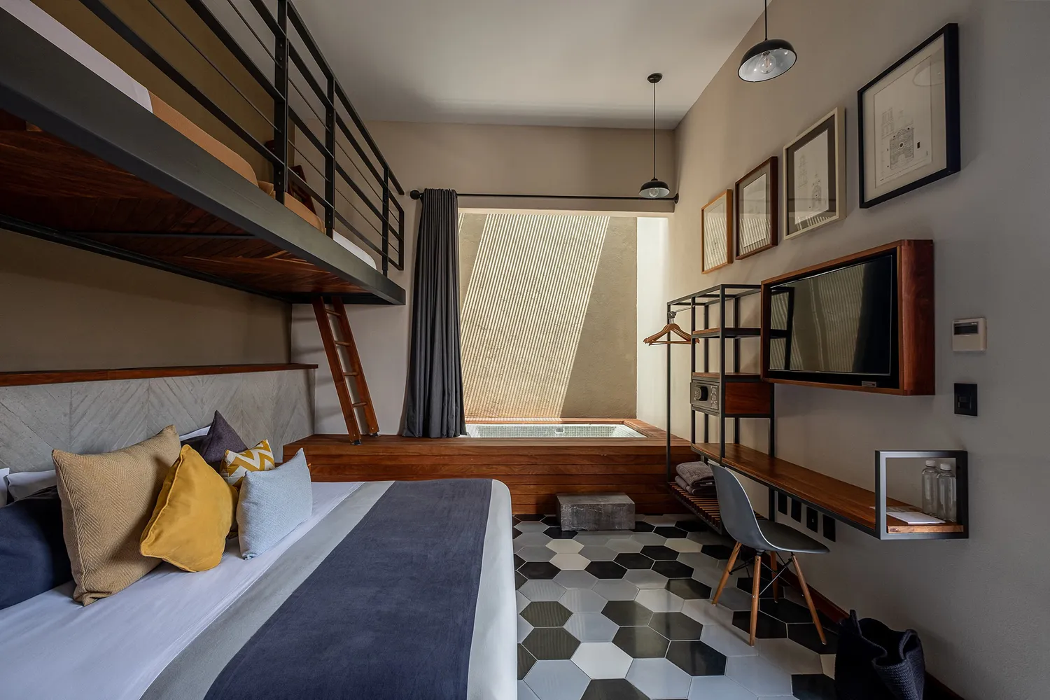 A modern boutique hotel room in Querétaro featuring a lofted bed, wooden accents, and contemporary art on the walls.