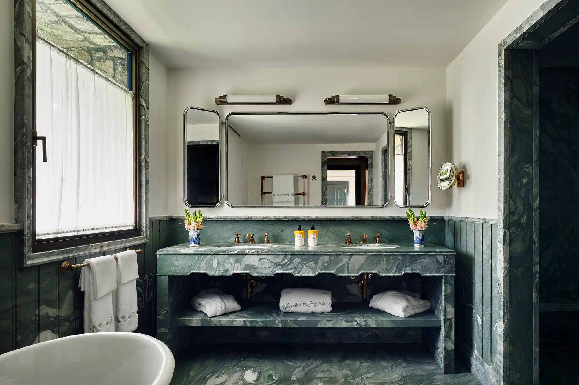 Detailed view of a luxury bathroom featuring double vanity and Cipollino marble surfaces.
