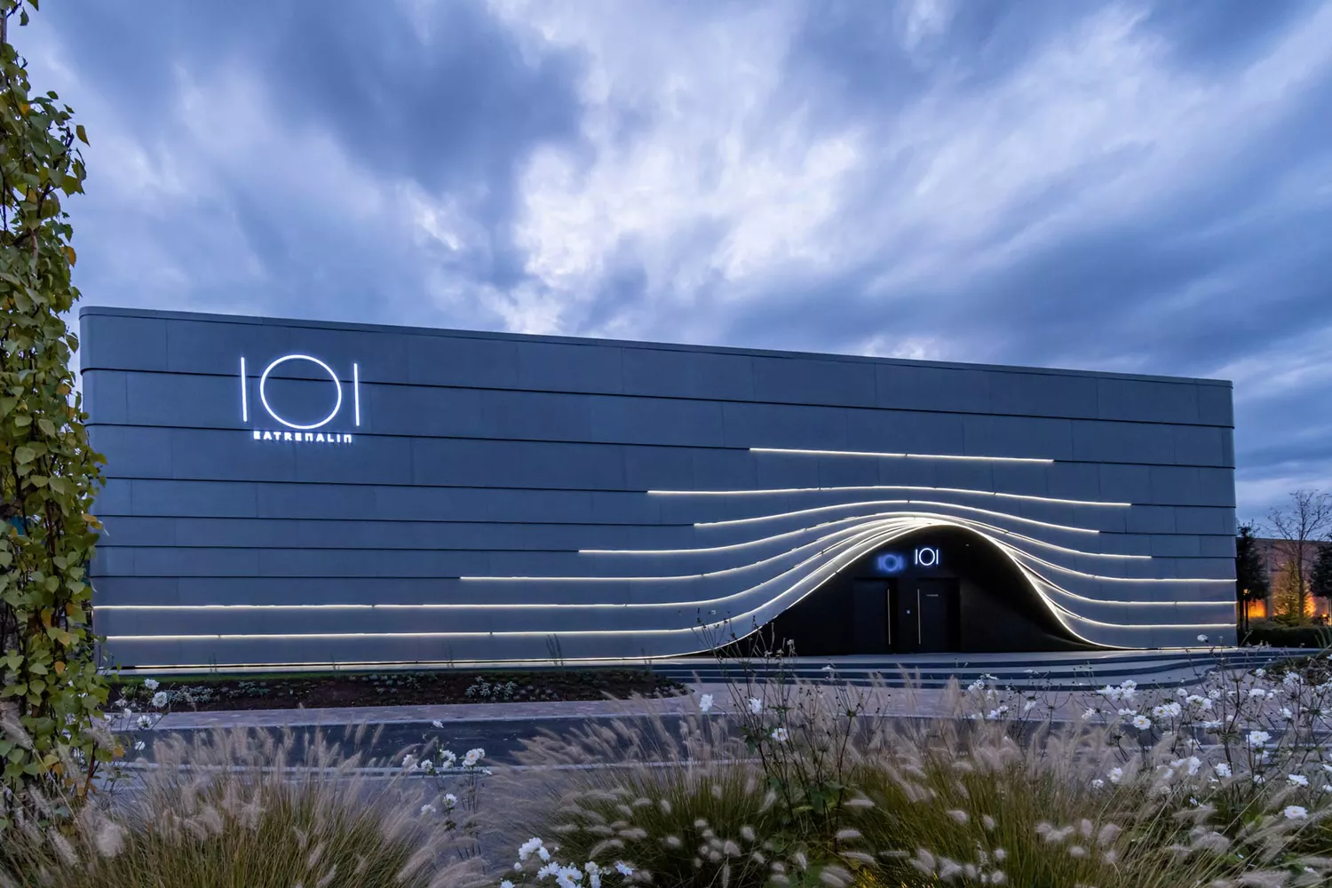 The sleek, modern exterior of the Eatrenalin building in Rust, Germany, illuminated during twilight.