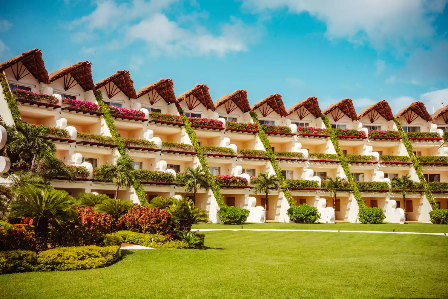 Architecture and exterior view of the Grand Velas Riviera Maya resort tucked into lush greens.