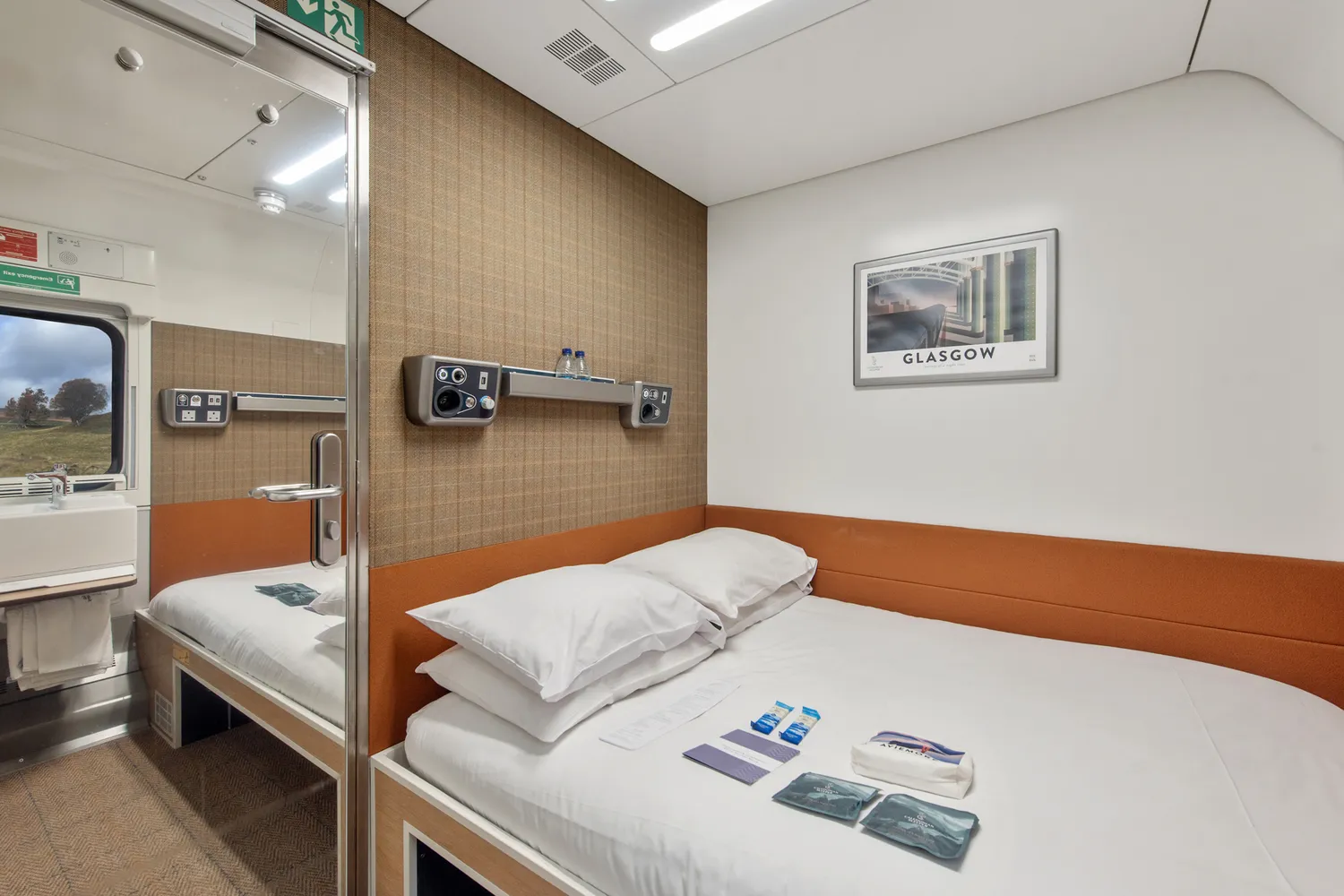 A modern Caledonian Double ensuite cabin featuring a double bed with white linens and a window view.