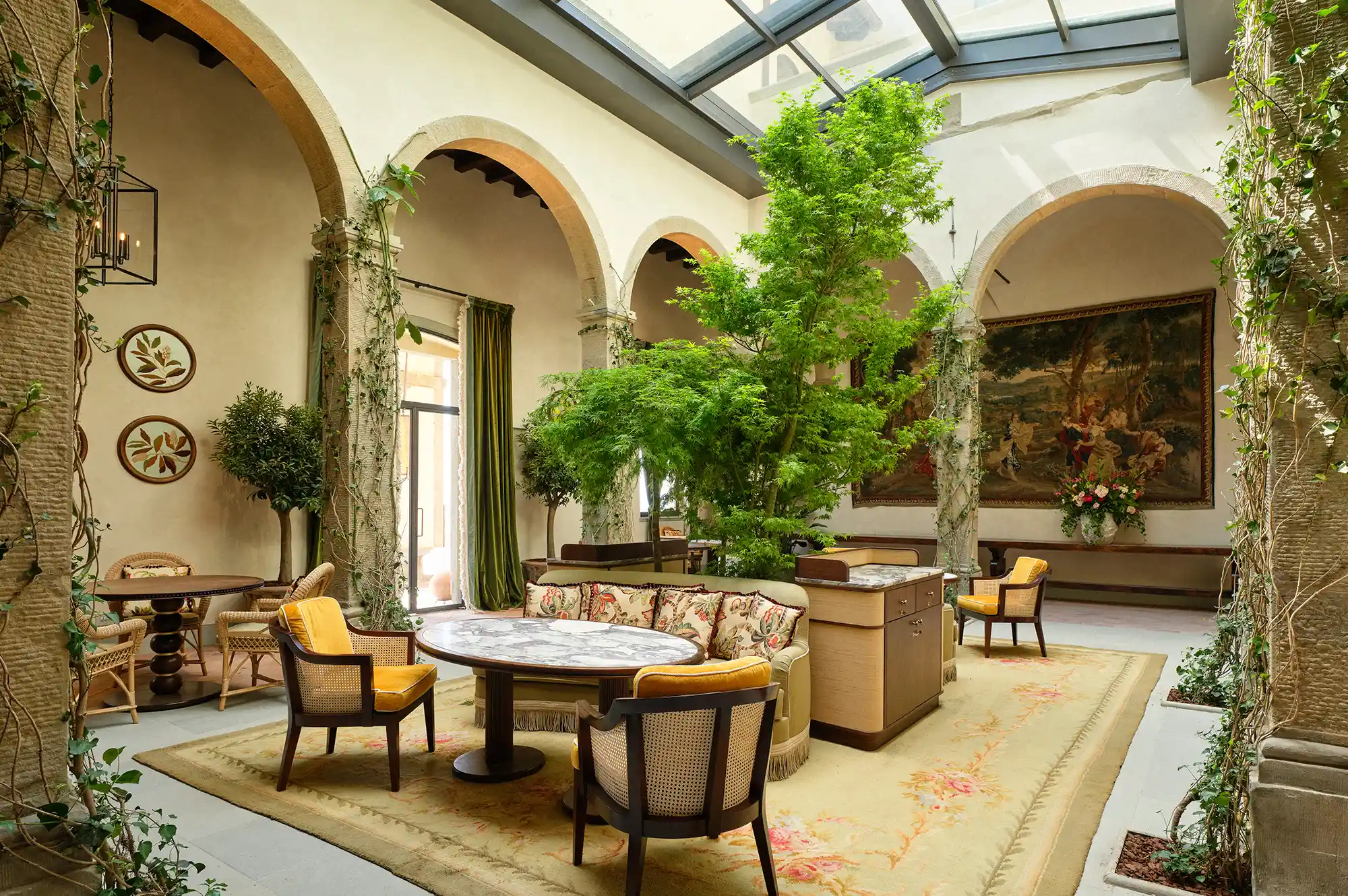 Interior view of the historic cloister with arches and a glass-ceiling skylight.