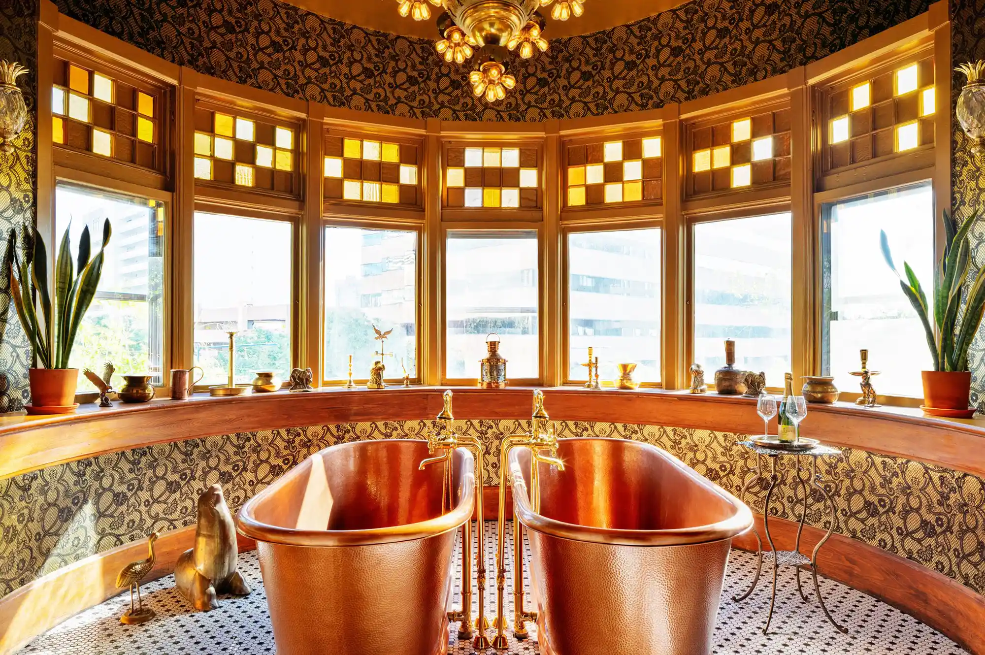 A luxurious bathroom featuring signature double copper clawfoot bathtubs against patterned tiles.
