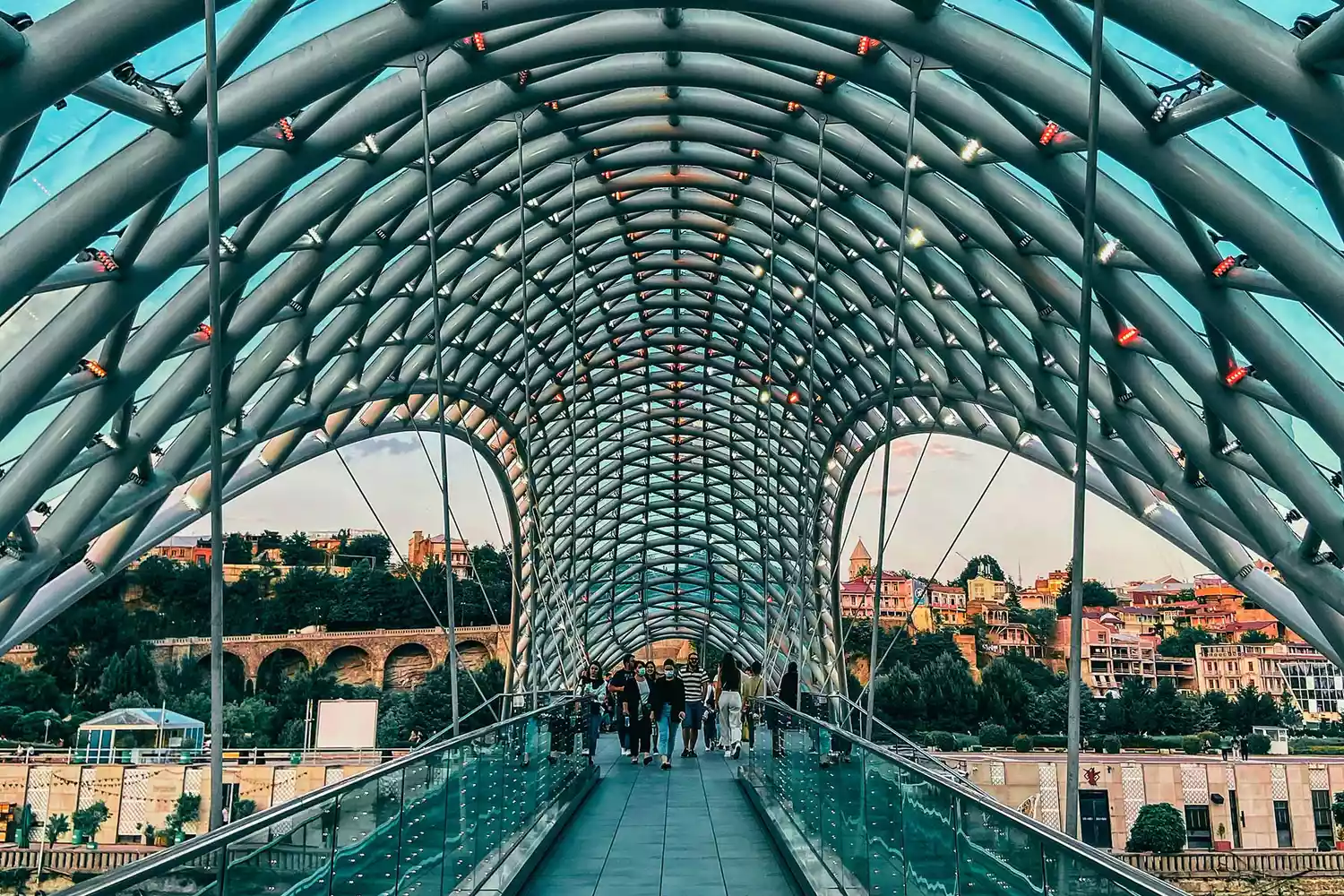 The illuminated glass and steel Bridge of Peace crossing the Mtkvari River in Tbilisi.