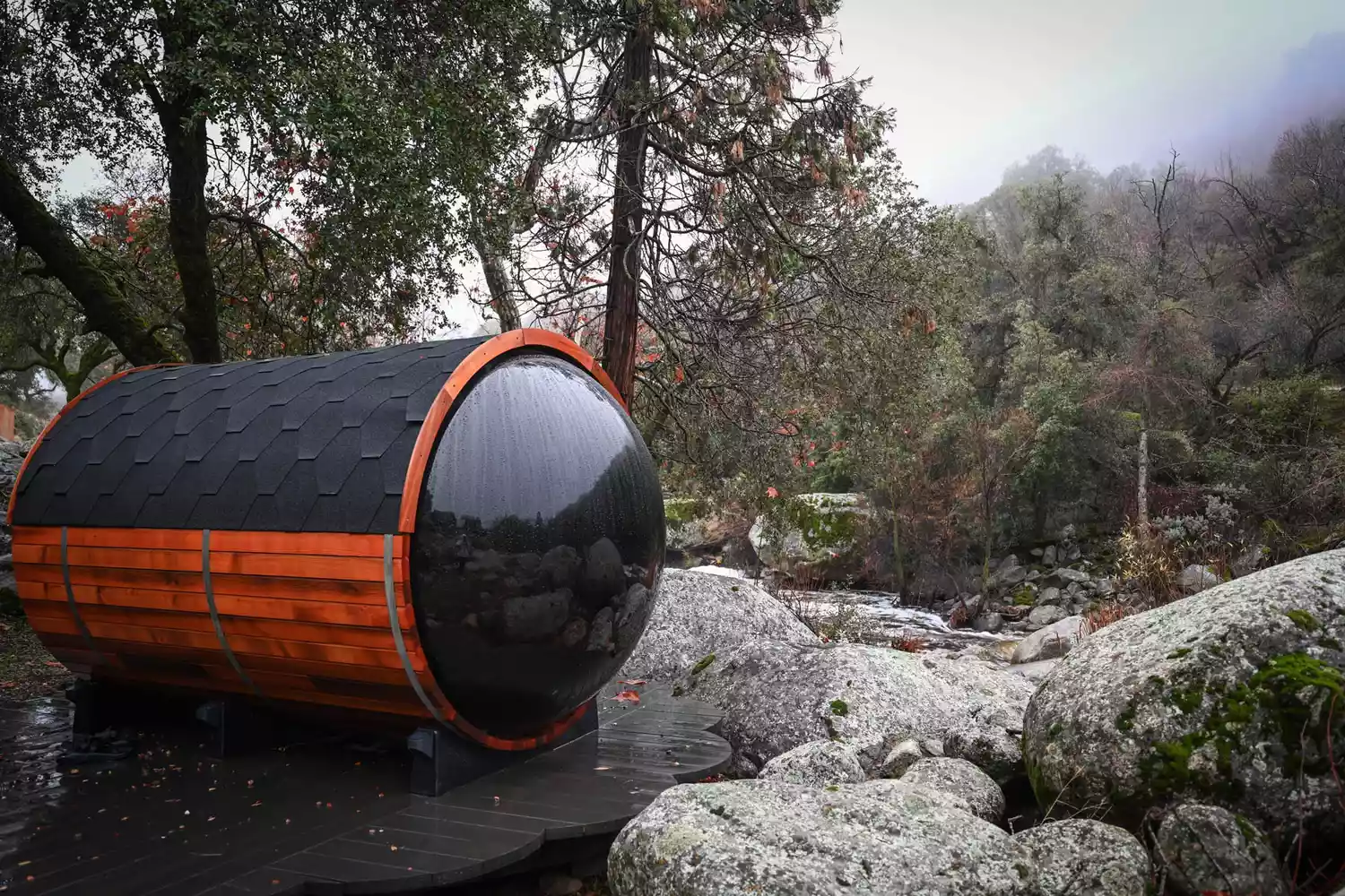 A traditional cedar barrel sauna situated on a wooden deck overlooking the forest at Paradise Ranch.