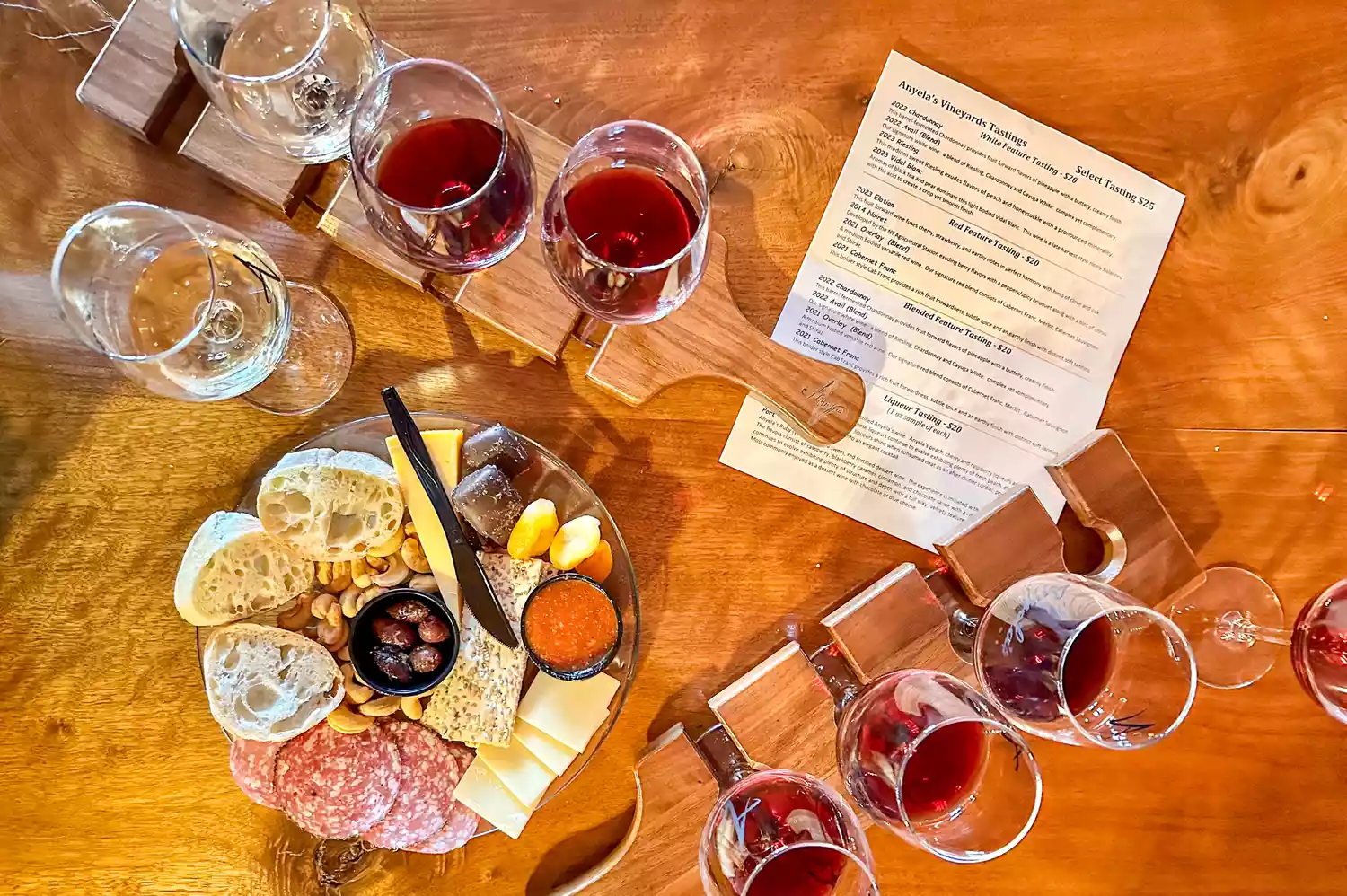 A gourmet charcuterie board served with several glasses of wine for a tasting.