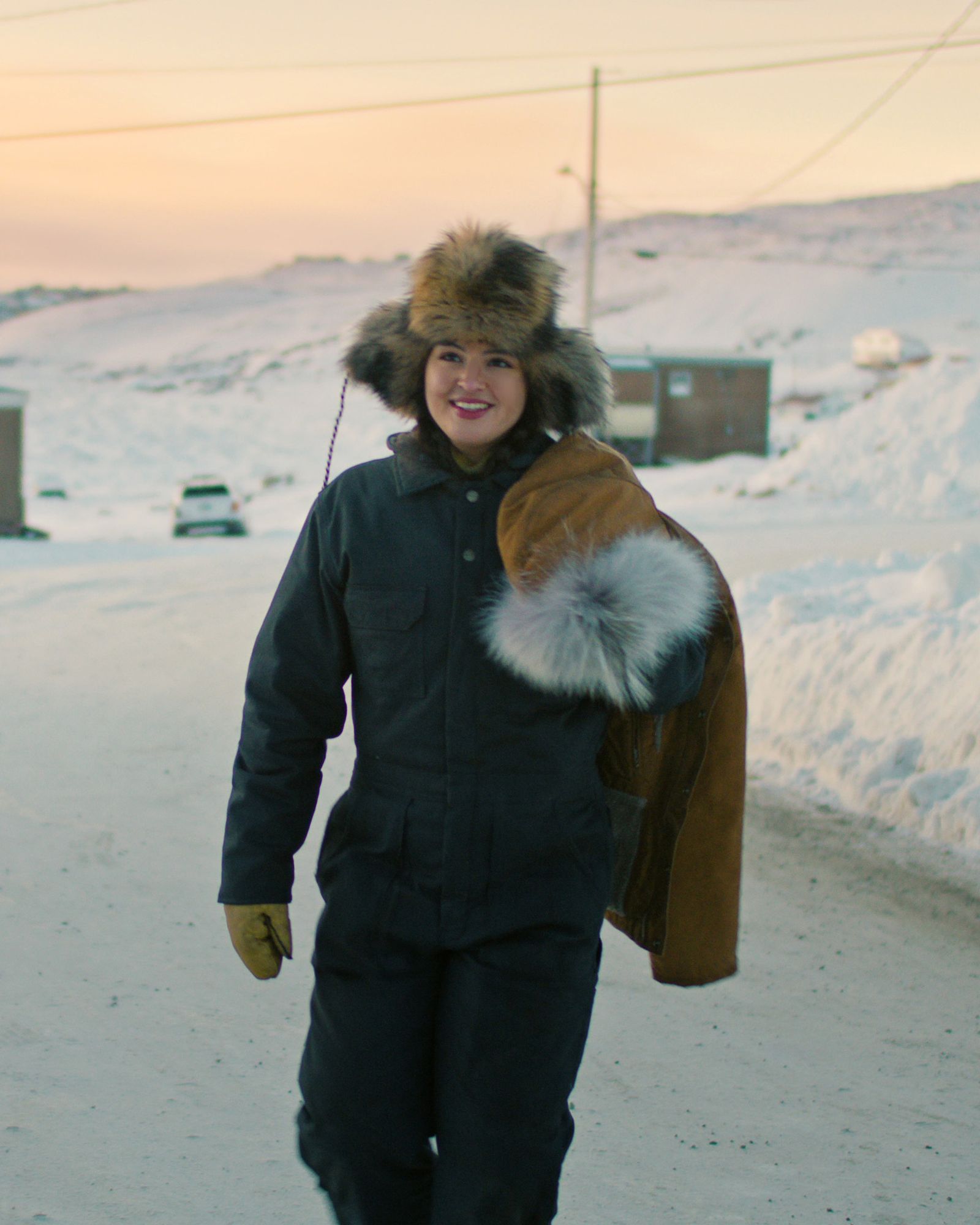 A person in high-performance outdoor winter clothing against a nature background.