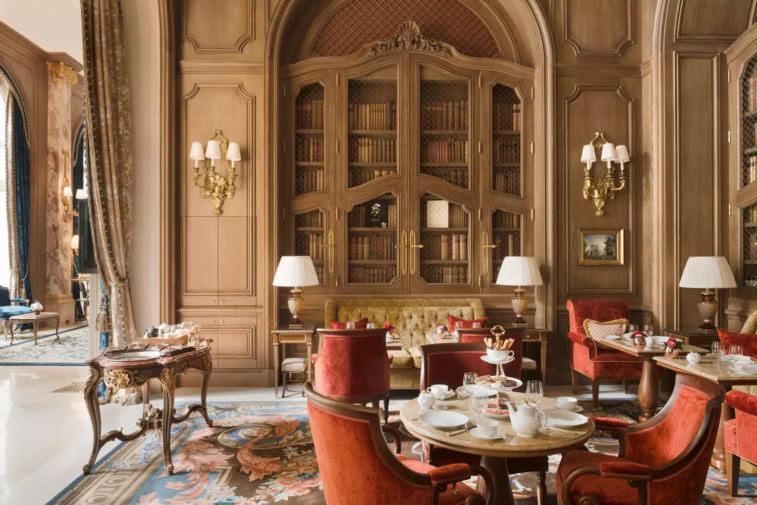 The extravagant and elegant dining room at the Ritz Paris with gold leaf and luxury table settings.