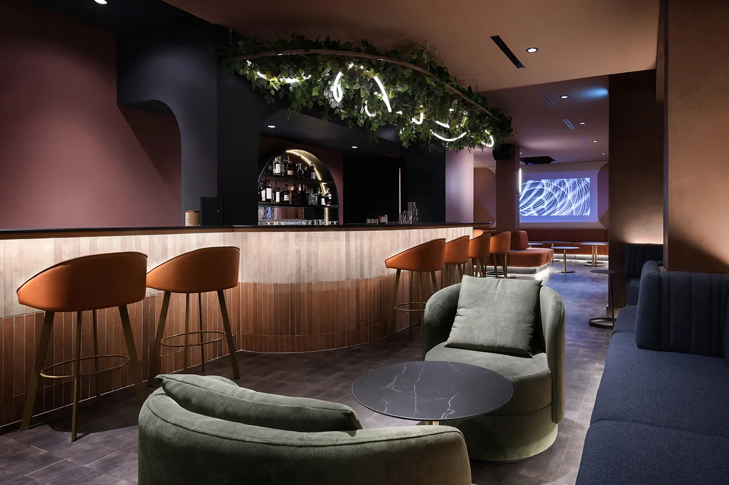 The Subterra Bar interior featuring green chairs and a large projection screen used for audio-visual events.