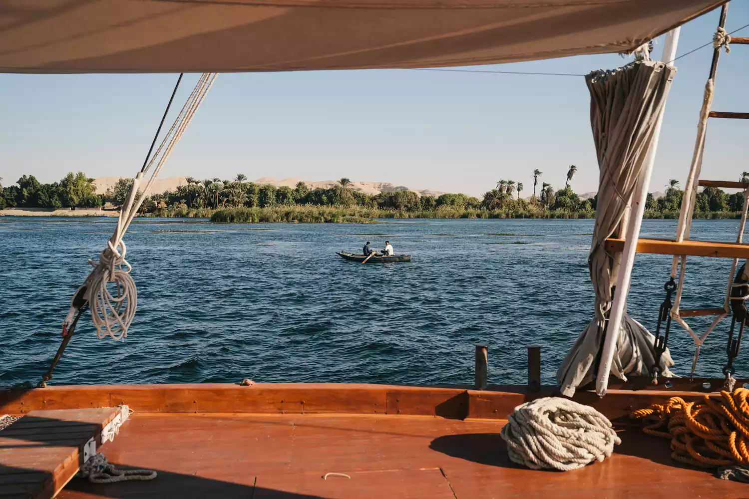 A peaceful view of the Nile riverbank taken from the deck of a boat.