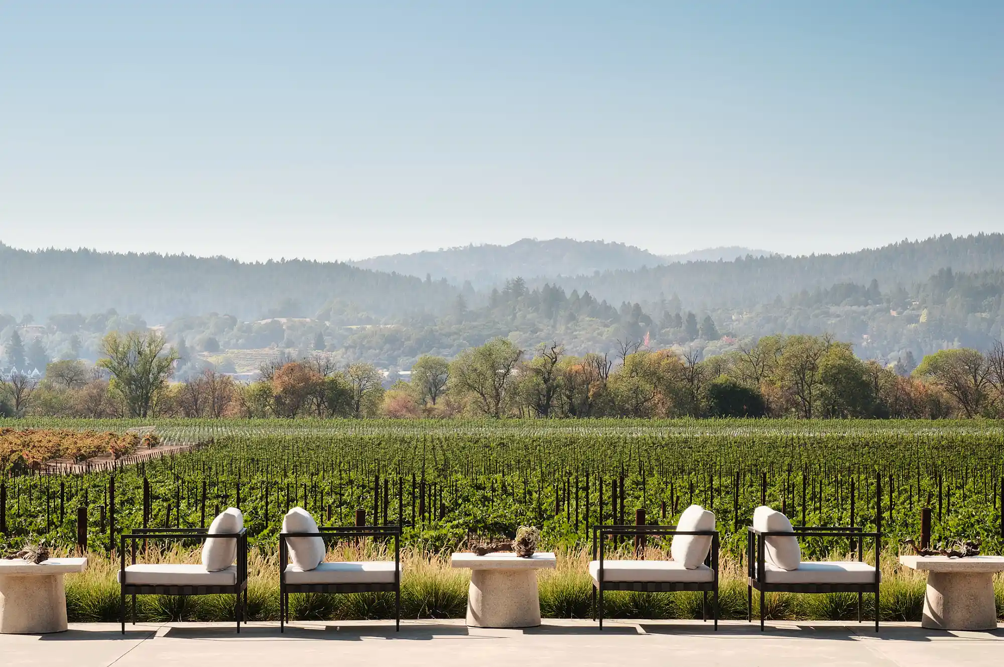 An outdoor patio with lounge chairs overlooking rolling vineyard hills at Montage Healdsburg.